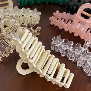 Macro shot of 13cm 3D flower acrylic hair claws in cream, pink, black, and green