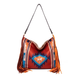 Detail of bohemian shoulder bag featuring orange tassels and ethnic woven patterns
