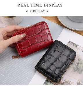 Detail view of red crocodile pattern leather card holder with gold zipper and accordion slots