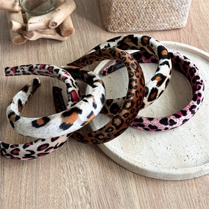 Top view of four velvet leopard print headbands in brown, beige, pink and colorful tones