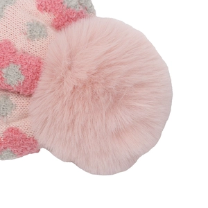 Gros plan du pompon en fausse fourrure et du motif en maille jacquard sur le bonnet
