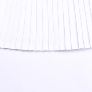 Close-up of pleated white fabric showing fine stitching and crisp pleats of the skirt