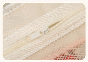 Detail of creamy mesh organizer bag with durable metal zipper and fine mesh texture