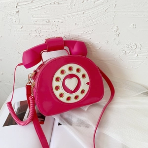 Close-up of heart pattern on magenta patent leather vintage telephone crossbody bag
