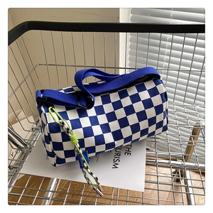 Blue and white checkerboard Boston bag in a shopping basket with focus on fabric texture