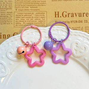 Macro detail of colorful star acrylic keychains with metal rings on a ceramic plate