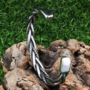 Macro view of Nordic woven C-shaped cuff bracelet with vintage twisted rope texture