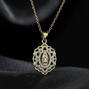 Gold Virgin Mary oval pendant necklace with sparkling rhinestones on black silk background