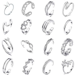Macro detail of various silver ring designs including butterfly, heart, and geometric patterns