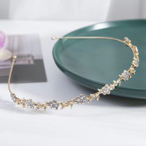 Sparkling flower headband with rhinestones and vine design on green ceramic plate
