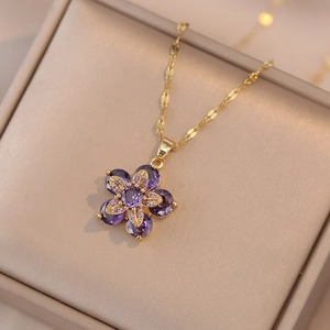 Elegante goldene Blumenkette mit lila Zirkonia-Blütenblättern in einer Samtschmuckschatulle