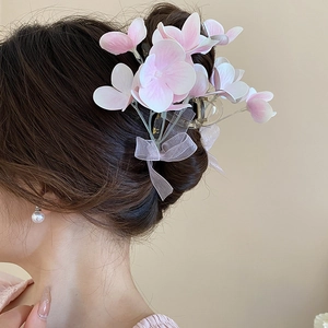 Pink and white floral bow hair claw clip styled on a model in a soft romantic look