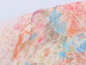 Gros plan sur tissu en mousseline à imprimé floral rose et bleu avec détails de broderie