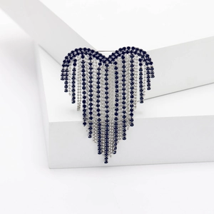 Elegant heart-shaped tassel brooch with deep blue stones and silver chain on white stand