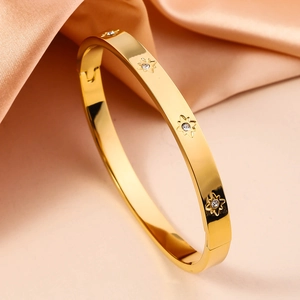 Macro shot of gold-plated stainless steel star bangle with sparkling zircon stones