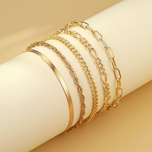 Detail view of 5-piece gold bracelet set featuring snake, cable, and paperclip chains