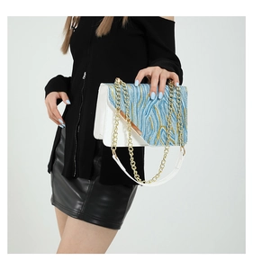 Detail of color-block flap bag with gold-textured fabric and chain strap