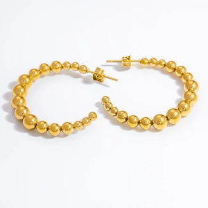 Detailed view of polished gold beaded hoop earrings with a gradient metallic bead design