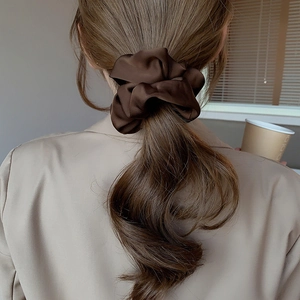 Elegant deep brown satin scrunchie hair tie shown on a ponytail with silky luster texture