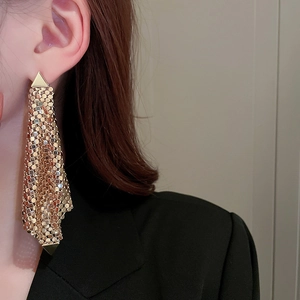 Gros plan de boucles d'oreilles en maille dorée avec un design triangulaire unique