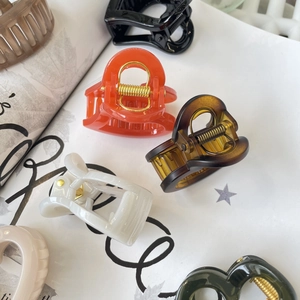 Minimalist heart-shaped hair claw clips in various colors with gold metal springs