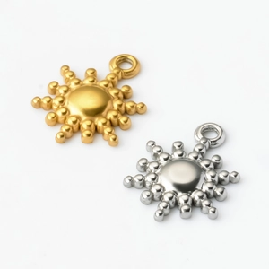 Detailed macro view of gold and silver sun star pendants in polished stainless steel
