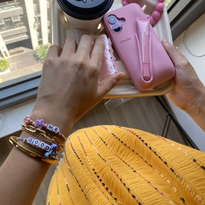 Rhode pink silicone phone case with integrated peptide lip tint held on a tray