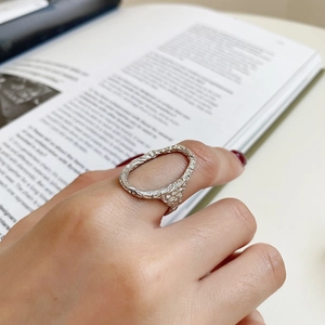 Close-up of irregular 925 sterling silver lava texture ring worn on hand with soft lighting