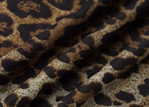 Close-up macro of premium leopard print knit fabric with detailed weave texture