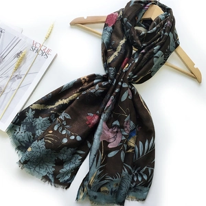 Detail of sateen floral scarf with blue and pink blossoms on deep brown background