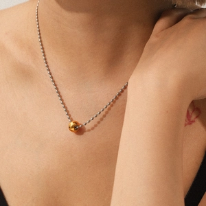 Close-up of dual-tone 18K gold and silver stainless steel beaded Y-necklace on neck