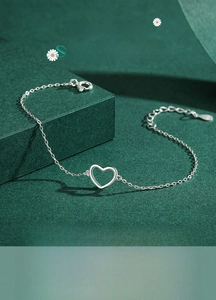 Macro shot of S925 sterling silver heart bracelet showing lobster clasp and adjustable chain