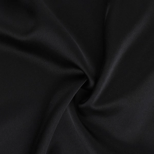 Detail shot of black silk satin fabric showing elegant drape and smooth glossy texture