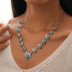 Detail of bohemian necklace with turquoise stones and crystals worn by a model