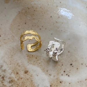 Close-up of S925 sterling silver rings with irregular wave texture in gold and silver