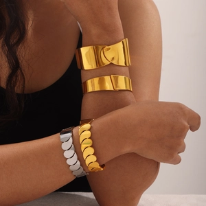Gold-tone wide minimalist bangles and layered metallic chain bracelets for women
