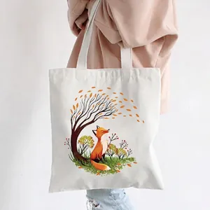 White canvas tote bag featuring an artistic autumn fox print carried by a model
