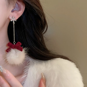Detail of snowflake earrings with red velvet bow and soft white plush pom-pom