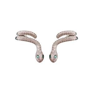 Silver snake-shaped wrap earrings with white crystals and green stone eyes on white background