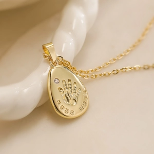 Collana con ciondolo ovale dorato con impronta di mano, incisione cinese e piccolo diamante