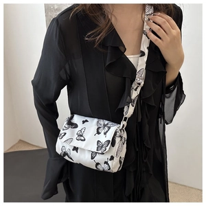 Chic butterfly print crossbody bag shown on model with matching pleated black top