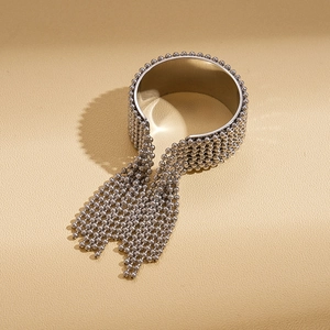 Makro-Detail von silbernem Edelstahl-Armreif mit Perlen und eleganten Metallfransen