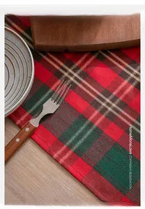 Close-up detail of red and green plaid table runner with festive fabric texture
