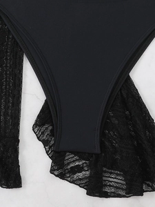 Close-up of black bikini swimwear showing elastic fabric and detailed floral lace texture