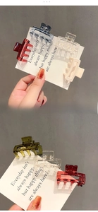 Dettaglio di fermagli per capelli quadrati in resina blu e bordeaux su carta
