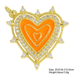 Macro view of gold heart pendant with orange enamel and cubic zirconia stones