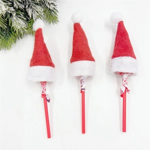 Close-up of three mini red felt Christmas hats placed on lollipops for holiday decor