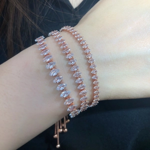 Close-up of adjustable rose gold marquise tennis bracelets worn in a three-layer stack
