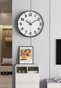 Detail of a minimalist 12-inch round wall clock with black frame on a modern gray wall