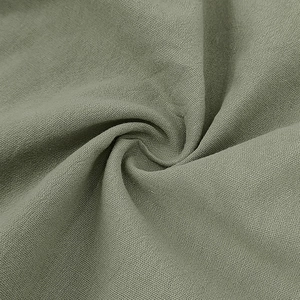 Detailed macro view of green linen fabric texture on men's casual polo shirt
